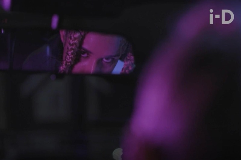 i-D video still: eyes in a rearview mirror, neon light