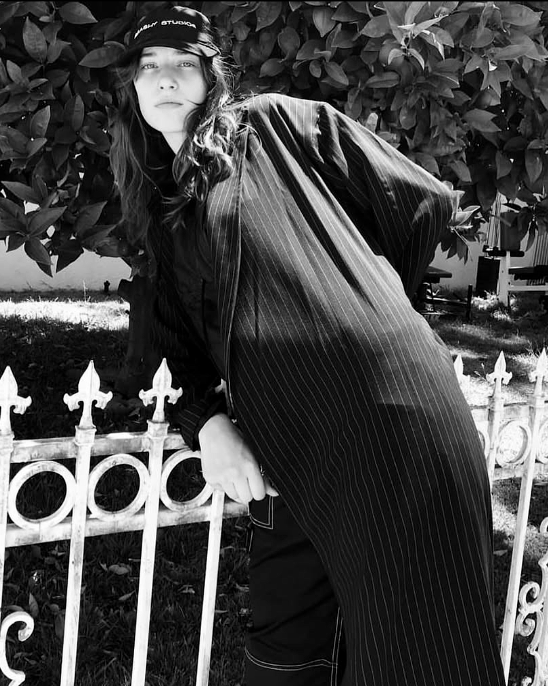 Sofia Tesmenitskaya leaning against a white iron fence.